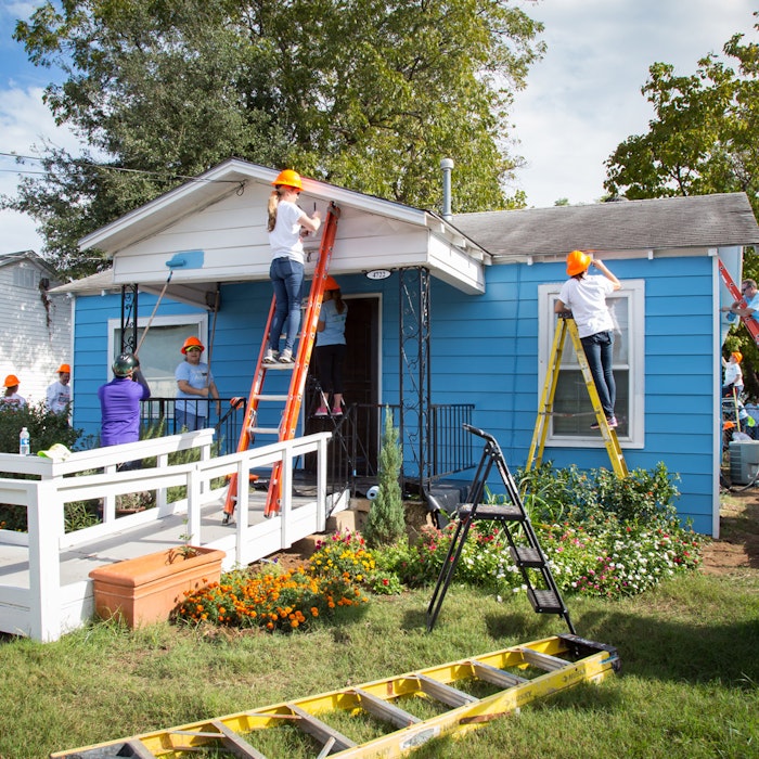 volunteers painting the exterior of a house
