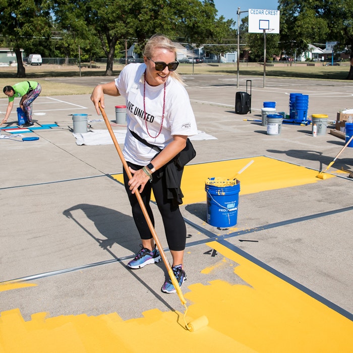 volunteer in LIVE UNITED shirt updating playground