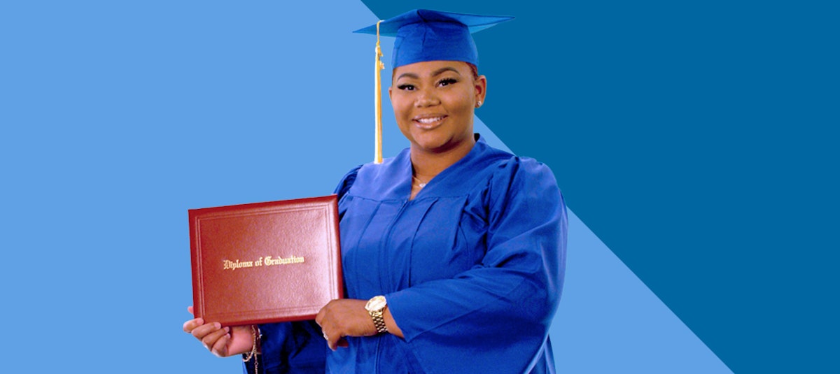 girl in a graduation gown holding up diploma