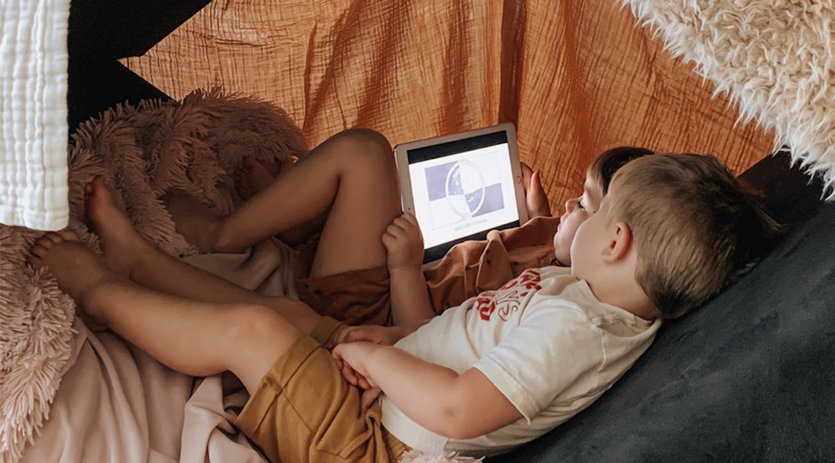 two kids under a fort reading a book via Vooks